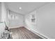 Bright room featuring wood floors, white walls, with an entry door, and lots of natural light from the windows at 4310 Crittenden Ave, Indianapolis, IN 46205