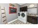 Well-lit laundry room with modern washer, dryer, custom cabinets, and charming decorative touches at 561 Farnham Dr, Westfield, IN 46074