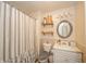 Charming bathroom with a vanity and round mirror, featuring decorative shelves and a shower with a stylish curtain at 610 E 1000 N, Fortville, IN 46040