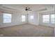 Bright bedroom featuring neutral carpet, ceiling fan, and many windows providing natural light at 6471 W Clearview Dr, McCordsville, IN 46055