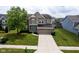Charming two-story home showcasing a well-manicured lawn and a beautiful turquoise front door at 6471 W Clearview Dr, McCordsville, IN 46055