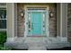 Close up of turquoise front door with decorative sidelights and a brick surround framed by stately columns at 6471 W Clearview Dr, McCordsville, IN 46055