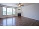 Bright living room with hardwood floors, a stone fireplace, and large windows for ample natural light at 6471 W Clearview Dr, McCordsville, IN 46055