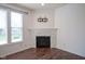 Corner view of a living room with a decorative fireplace, hardwood floors and bright natural light at 6471 W Clearview Dr, McCordsville, IN 46055