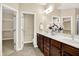 Bathroom featuring double sink vanity, white countertop, dark cabinetry, and walk-in closet at 6691 Beekman Pl, Zionsville, IN 46077