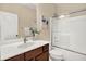 Bathroom featuring vanity with white countertop, dark cabinetry, and a shower-tub combo at 6691 Beekman Pl, Zionsville, IN 46077