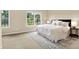 Bright bedroom with neutral carpet, a large window with backyard views, and a queen size bed with side tables at 6691 Beekman Pl, Zionsville, IN 46077
