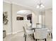 Dining area with a glass table and views into the kitchen; neutral paint throughout at 6691 Beekman Pl, Zionsville, IN 46077