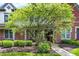 Inviting brick home with a well-maintained front yard, mature tree, and colorful flowerbeds at 6691 Beekman Pl, Zionsville, IN 46077