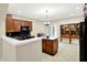 Bright kitchen features a stone countertop island, black appliances, wood cabinets, and an open layout at 6691 Beekman Pl, Zionsville, IN 46077