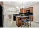 Charming kitchen boasts wooden cabinets, black appliances, a stone countertop island with seating, and views into the living areas at 6691 Beekman Pl, Zionsville, IN 46077