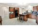 Charming kitchen boasts wooden cabinets, black appliances, a stone countertop island with seating, and views into the living areas at 6691 Beekman Pl, Zionsville, IN 46077