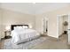 Bright main bedroom features neutral carpet, a king size bed, side tables, and backyard views through a large window at 6691 Beekman Pl, Zionsville, IN 46077