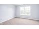 Bright bedroom with neutral carpet and a large window showing natural light at 6955 Long Run Dr, Indianapolis, IN 46268