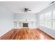 Spacious living room featuring hardwood floors, built-in shelving, fireplace and a ceiling fan at 6955 Long Run Dr, Indianapolis, IN 46268