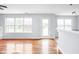 Bright and airy living room with hardwood floors and multiple windows overlooking the landscape at 6955 Long Run Dr, Indianapolis, IN 46268