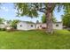 Expansive backyard with a wooden deck, planter, and mature tree, offering space for gardening and relaxation at 717 Berkeley Dr, Shelbyville, IN 46176