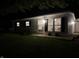 Night view of a single-story home with well-kept lawn and detached garage at 717 Berkeley Dr, Shelbyville, IN 46176