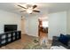 Open living room with hardwood floors, a ceiling fan, and a modern entertainment center at 717 Berkeley Dr, Shelbyville, IN 46176