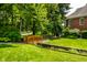 A charming wooden bridge spans a gentle stream on a well-manicured lawn behind the house at 7341 Washington Blvd, Indianapolis, IN 46240