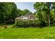 Expansive lawn showcasing a brick house surrounded by lush trees and a wooden bridge at 7341 Washington Blvd, Indianapolis, IN 46240