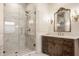 Modern bathroom featuring marble walk-in shower, custom vanity with decorative mirror and sconces at 7341 Washington Blvd, Indianapolis, IN 46240