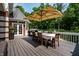 Outdoor deck with dining table set, umbrella, grill, and access to the beautiful backyard at 7341 Washington Blvd, Indianapolis, IN 46240