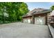 Spacious three-car garage with large driveway and basketball hoop, surrounded by lush greenery at 7341 Washington Blvd, Indianapolis, IN 46240
