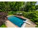 Aerial view of a backyard pool featuring lounge chairs with umbrellas and well-manicured greenery at 7341 Washington Blvd, Indianapolis, IN 46240