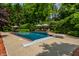 Inviting backyard pool with lounge chairs, umbrellas, and lush greenery for ultimate relaxation at 7341 Washington Blvd, Indianapolis, IN 46240