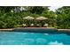 Relaxing poolside featuring lounge chairs with umbrellas, perfect for serene outdoor enjoyment at 7341 Washington Blvd, Indianapolis, IN 46240