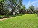 Large grassy backyard with back deck, home, shed, and mature trees at 7434 N Green Meadows, Fairland, IN 46126