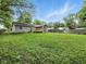 Large grassy backyard with back deck, home, and privacy fence at 7434 N Green Meadows, Fairland, IN 46126