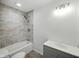 Updated bathroom with gray tile, a shower-tub combo, modern lighting, and a gray vanity at 7434 N Green Meadows, Fairland, IN 46126