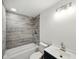 Updated bathroom with a gray-tiled shower/tub combo, modern lighting, and sleek fixtures at 7434 N Green Meadows, Fairland, IN 46126