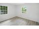 Bedroom has gray wood floors, two windows, and white walls with recessed lighting at 7434 N Green Meadows, Fairland, IN 46126