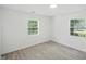 This bright bedroom features gray wood floors, two windows, and white walls and trim at 7434 N Green Meadows, Fairland, IN 46126