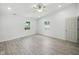 Bright bedroom with gray wood floors, two windows, white walls and trim, and ceiling fan at 7434 N Green Meadows, Fairland, IN 46126