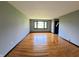 Living room with gleaming hardwood floors and a large window for natural light at 771 Doran Ave, Shelbyville, IN 46176