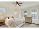 Bright bedroom featuring neutral walls, carpet flooring, ceiling fan, and comfortable queen size bed with decorative pillows at 776 Templeton Dr, Carmel, IN 46032