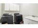 Functional laundry room complete with black appliances, a utility sink, and storage cabinets for efficient organization at 776 Templeton Dr, Carmel, IN 46032