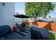 Charming back deck featuring a patio table, grill and an umbrella for outdoor enjoyment and relaxation at 806 Shelby St, Indianapolis, IN 46203