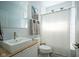 Bright bathroom featuring modern vanity, rectangular sink, and shower with light colored tile at 806 Shelby St, Indianapolis, IN 46203