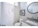 Stylish half-bath with a granite countertop, decorative mirror, and modern fixtures at 806 Shelby St, Indianapolis, IN 46203