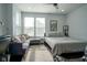 Cozy bedroom featuring a queen bed, a gray couch, light blue walls, and a ceiling fan at 806 Shelby St, Indianapolis, IN 46203