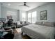 Comfortable bedroom with queen bed, desk, dark wood floors, ceiling fan, and lots of natural light at 806 Shelby St, Indianapolis, IN 46203