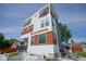 Modern three-story home featuring a white exterior with wood accents, balconies, and a picket fence at 806 Shelby St, Indianapolis, IN 46203