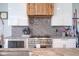 Updated kitchen with stainless steel appliances, range hood, granite countertops, and stylish backsplash at 806 Shelby St, Indianapolis, IN 46203