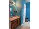 Bright bathroom features a blue textured wall, modern vanity and ample storage at 8113 Maple Stream Ln, Indianapolis, IN 46217