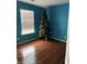Vacant bedroom features wood floors, a window, and blue walls at 8113 Maple Stream Ln, Indianapolis, IN 46217